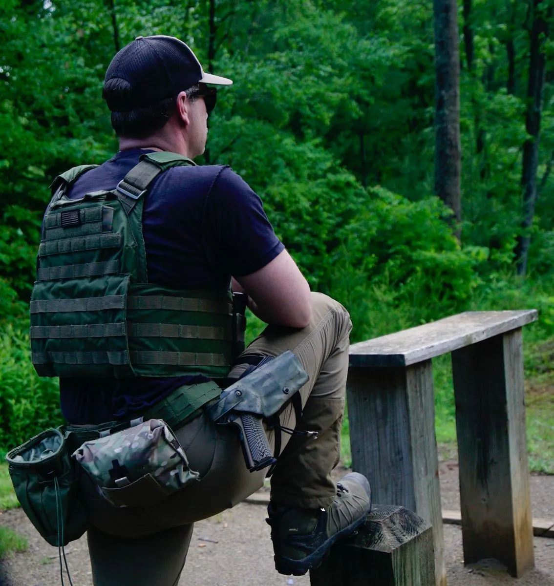 Colin Buchanan, founder of Pl8tek, in tactical gear looking out over a wooded range in North Carolina