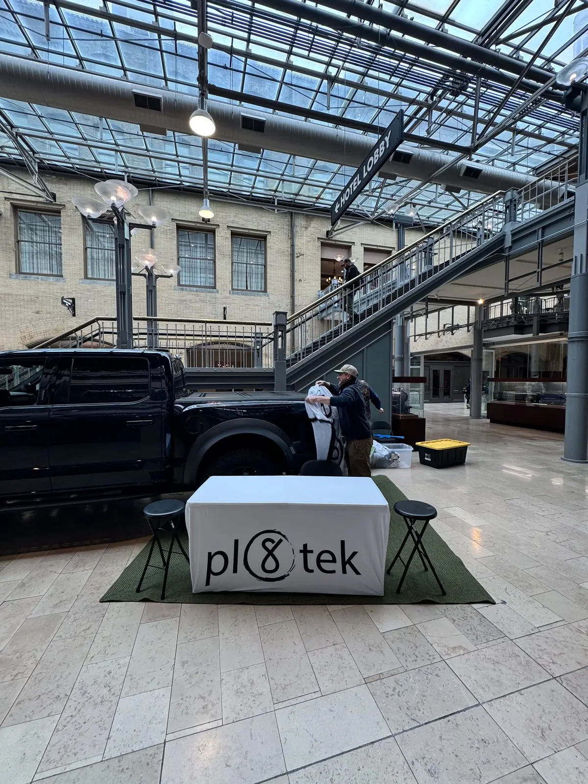 The Pl8tek booth set up with a branded table beside the display truck.
