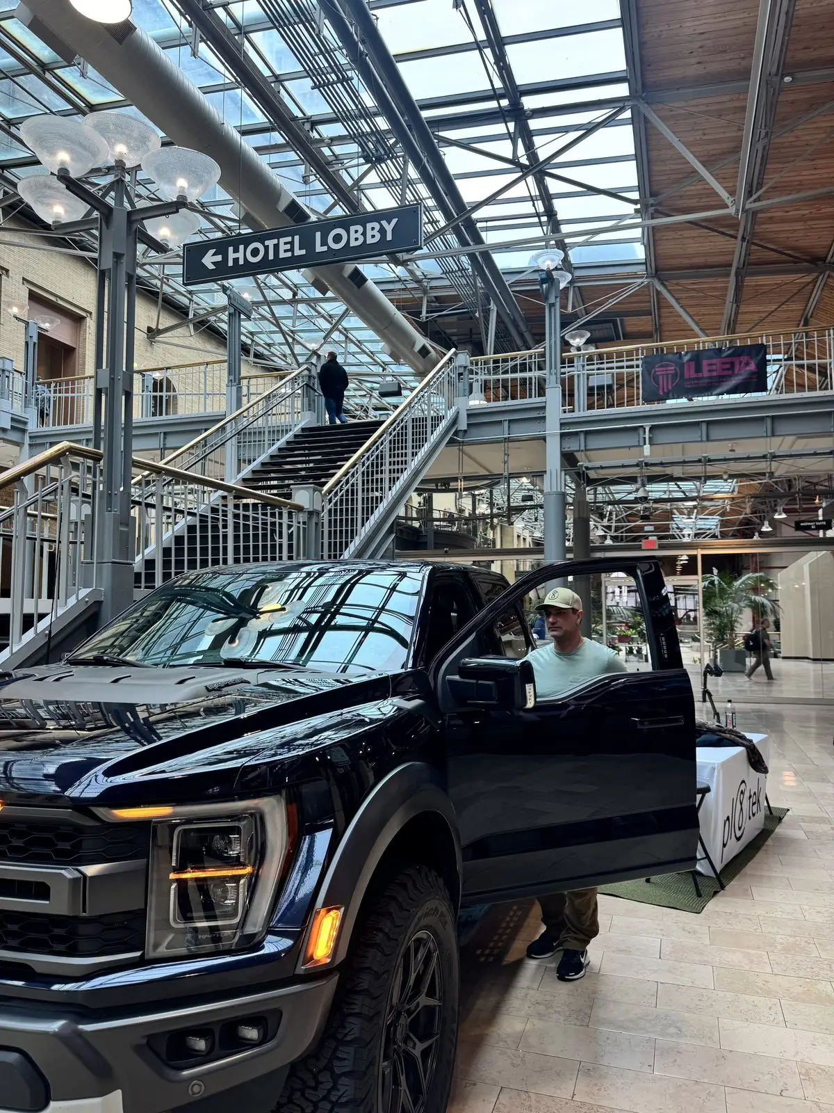 A black full-size truck displaying the StandA.R.D. vehicle rifle mount at the Pl8tek booth.
