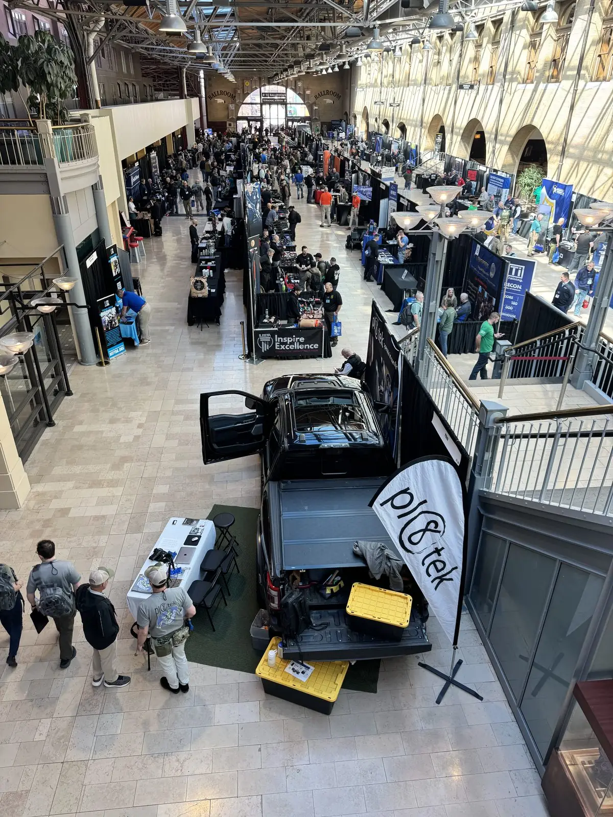 Overhead view of the ILEETA expo hall floor with attendees and the Pl8tek truck booth.