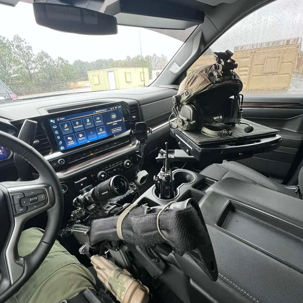 StandA.R.D. vehicle rifle mount in a patrol truck cab, rifle in the cradle and a ballistic helmet on the dash